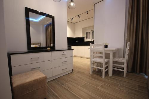 a bathroom with a dresser with a mirror and a table at Klea Rooms in Himare