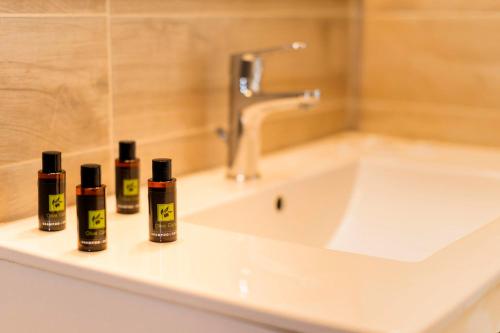 three bottles ofodorizers sit on a bathroom sink at Lefka Hotel & Apartments in Rhodes Town