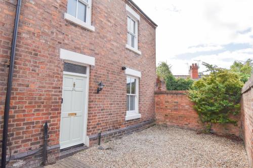 a brick house with a white door at Central Stays - Luxury Central Townhouse - With Free Parking in Chester