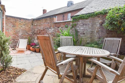 a wooden table and chairs on a patio at Central Stays - Luxury Central Townhouse - With Free Parking in Chester