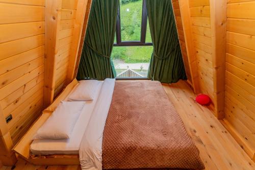 a small bed in a room with a window at Kervan Konaklama in Ardeşen