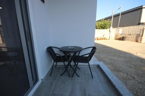 a small table and two chairs on a patio at Klea Rooms in Himare