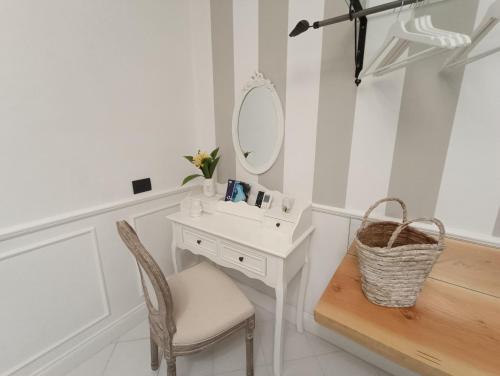 a bathroom with a sink and a mirror and a chair at Relais Tiaré Bed and Breakfast in Bacoli
