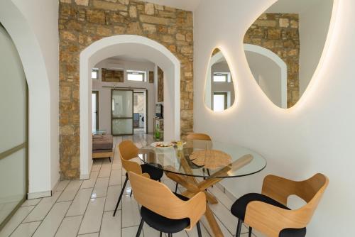 a dining room with a glass table and chairs at Lefka Hotel & Apartments in Rhodes Town
