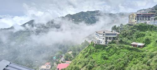 a mountain with buildings on top of a hill at The Novello By evergreen in Mussoorie