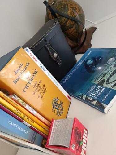 a pile of books sitting on a table with a wallet at Relais Tiaré Bed and Breakfast in Bacoli