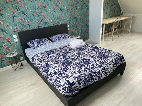 une chambre avec un lit avec une couette bleue et blanche dans l'établissement Ker Breizh, à Saint-Brieuc