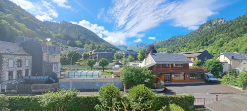 a town in a valley with mountains in the background at Alti'Pic Hôtel in Le Mont-Dore