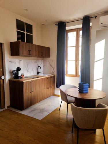 une cuisine avec une table et un évier et une table et des chaises dans l'établissement Casita Suite Hyper centre Sarlat, à Sarlat-la-Canéda