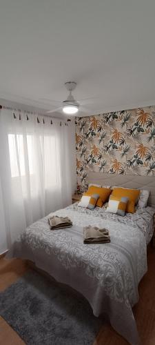 a bedroom with a large bed with yellow pillows at Apartamento Isabel in Torrevieja