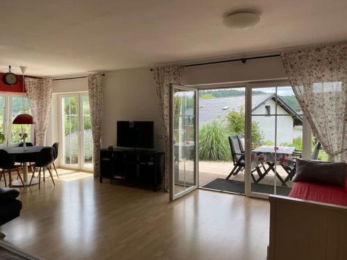 a living room with a sliding glass door and a dining room at Ferienwohnung Nauborn in Wetzlar mit großer Terrassse, ruhig gelegen in Wetzlar
