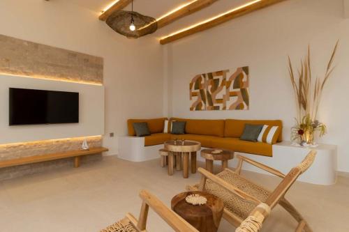 a living room with a couch and a tv at Ionian Blue Luxury Apartment in Marathopolis