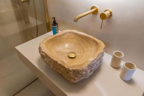 a bathroom with a wooden sink on a counter at Ionian Blue Luxury Apartment in Marathopolis
