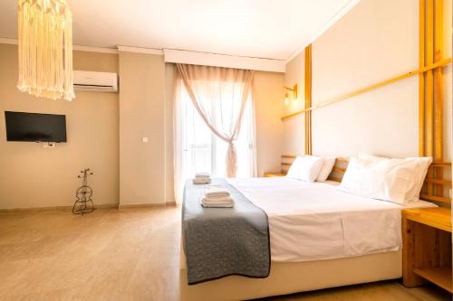 a bedroom with a large white bed and a window at Lefka Hotel & Apartments in Rhodes Town