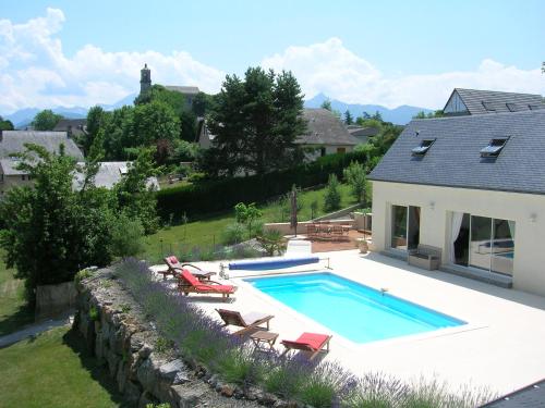 une piscine avec des chaises et une maison dans l'établissement Le GITE à JP, à Montgaillard