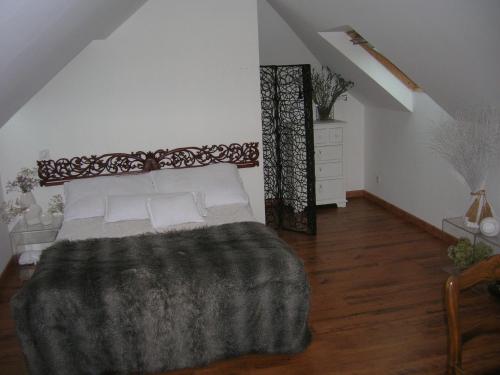 - une chambre avec un lit et une couverture grise dans l'établissement Le GITE à JP, à Montgaillard