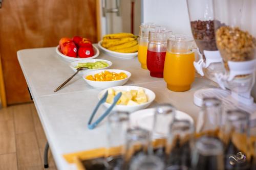 a table topped with bowls of fruit and juice at Vistara Suites in Iquique