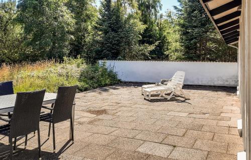a patio with chairs and a table and a bench at 3 Bedroom Amazing Home In Ålbæk in Ålbæk