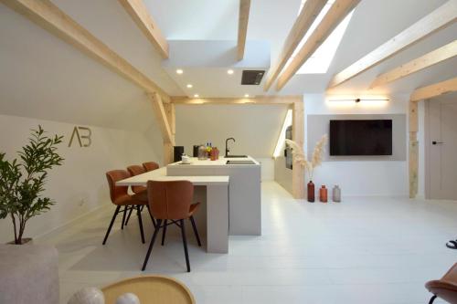 a kitchen and living room with a table and chairs at Apartamenty Blanca in Łeba