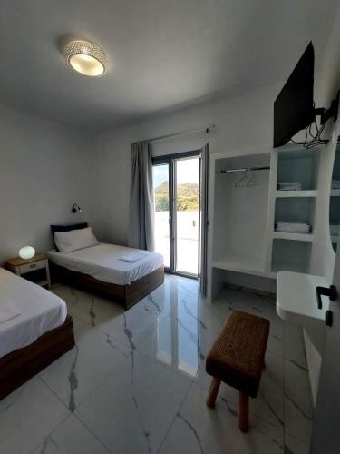 a hotel room with two beds and a television at Cledari Plaka Appartments in Plaka