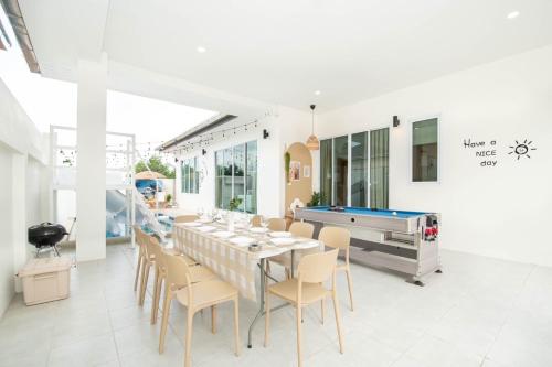 a dining room with a pool table and chairs at Teddy House Cozy 3BD Poolvilla near Jomtien beach in Ban Huai Yai