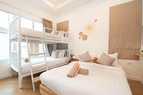 2 Betten in einem Zimmer mit 2 Etagenbetten in der Unterkunft Teddy House Cozy 3BD Poolvilla near Jomtien beach in Ban Huai Yai