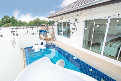 a swimming pool in front of a house at Teddy House Cozy 3BD Poolvilla near Jomtien beach in Ban Huai Yai