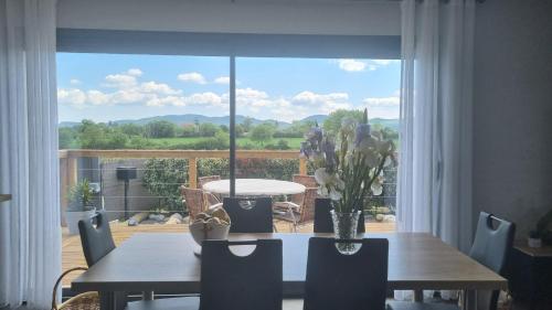 une salle à manger avec une table et une grande fenêtre dans l'établissement Villa Fidgj, à Berrias Et Casteljau