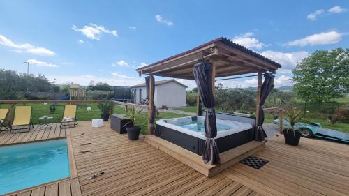 bañera de hidromasaje en una terraza junto a la piscina en Villa Fidgj, en Berrias Et Casteljau