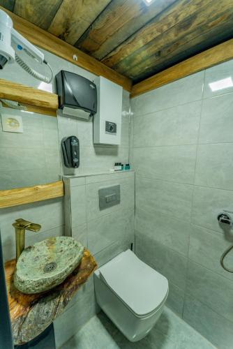a small bathroom with a toilet and a tv at Kervan Konaklama in Ardeşen