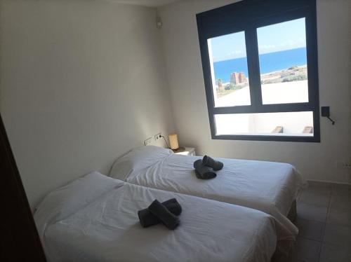 two beds with black bows on them in a room at Apartamento Califato 5 in Mojácar