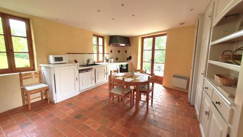 une cuisine avec une table et quelques chaises dans l'établissement Domaine de Montvianeix, à Saint-Victor-Montvianeix