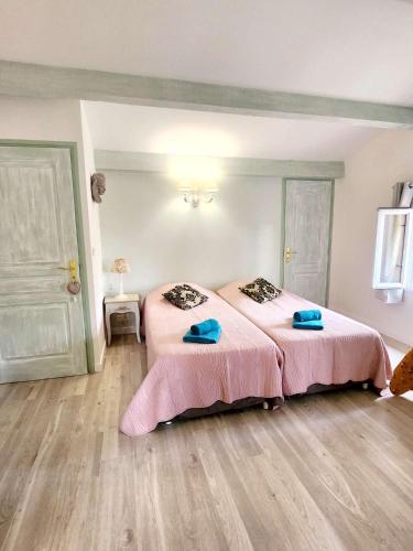 a bedroom with two beds with pink sheets at Le Clos Renaissance in Oppède