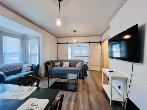 a living room with a couch and a tv at Relaxing 4 bedroom walk to the falls sleeps 8 in Niagara Falls