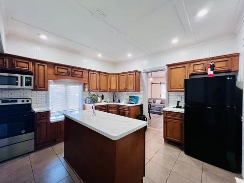 a kitchen with wooden cabinets and a black refrigerator at Relaxing 4 bedroom walk to the falls sleeps 8 in Niagara Falls