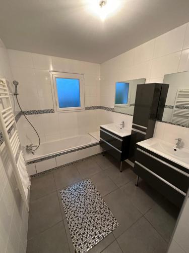 une salle de bain avec une baignoire et un lavabo et une baignoire dans l'établissement Villa grand séjour, à Saint-Georges-lès-Baillargeaux