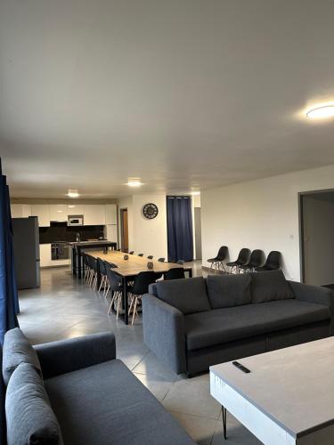 - un salon avec des canapés, une table et un piano dans l'établissement Villa grand séjour, à Saint-Georges-lès-Baillargeaux