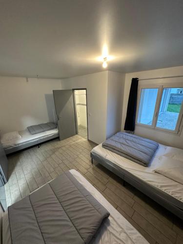 une chambre avec deux lits et une grande fenêtre dans l'établissement Villa grand séjour, à Saint-Georges-lès-Baillargeaux