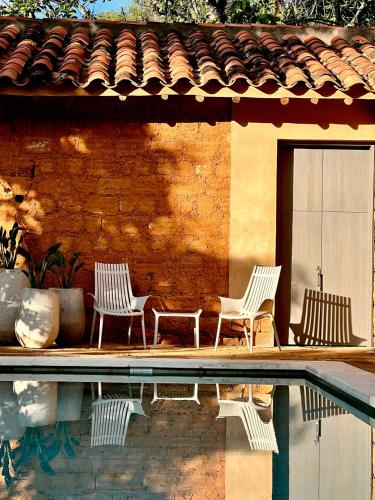 three chairs sitting next to a house with a swimming pool at Terrazul Barichara in Barichara