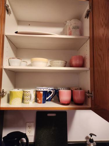 a cupboard filled with lots of bowls and plates at Winnipeg Place to Stay in Winnipeg