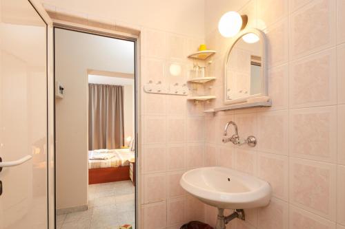 a white bathroom with a sink and a mirror at Villa Nasko Chaushev in Nesebar