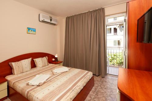 a bedroom with a bed with a television and a window at Villa Nasko Chaushev in Nesebar