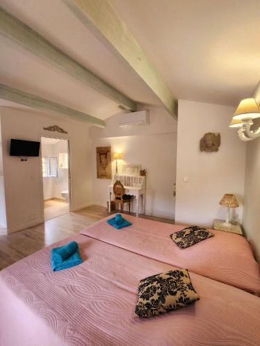 two beds in a room with two blue pillows at Le Clos Renaissance in Oppède