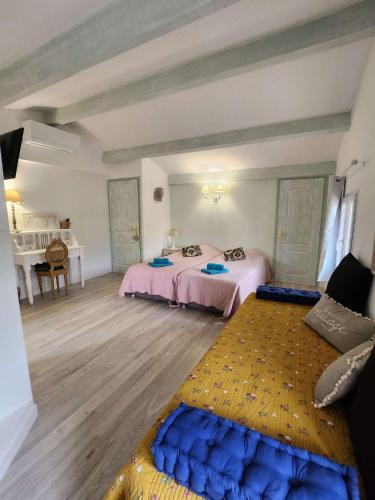 a large room with two beds and a table at Le Clos Renaissance in Oppède