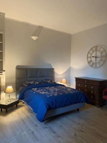 une chambre avec un lit et une horloge au mur dans l'établissement Appartement Brasserie du Jard 2 chambres, à Châlons-en-Champagne