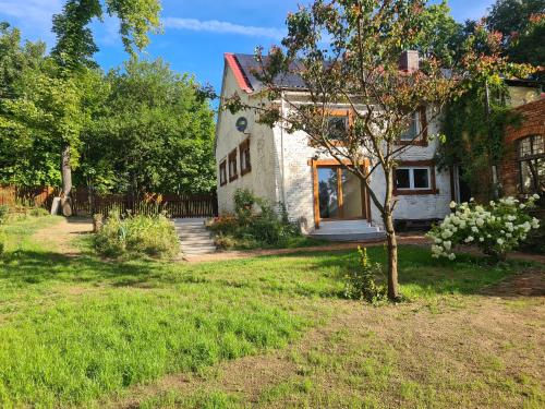 a white house with a tree in the yard at Dom z Klimatem in Wałbrzych