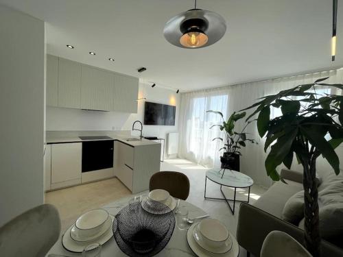 une cuisine et un salon avec une table dans la chambre dans l'établissement Elegant Penthouse Paris Panorama, à Colombes