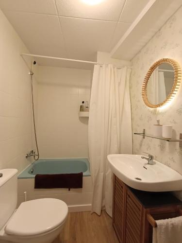 a bathroom with a toilet and a sink and a tub at La Casa del Chellero in Enguera