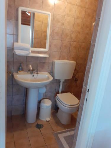 a bathroom with a sink and a toilet and a mirror at View apartment in Lefokastro
