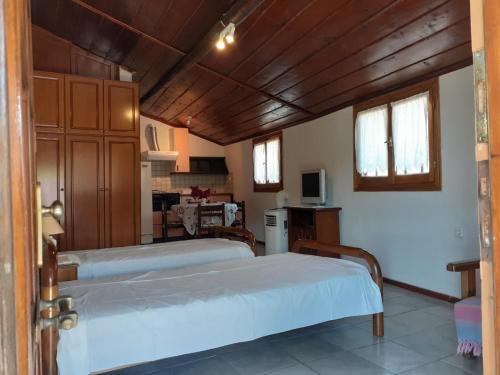 two beds in a room with a kitchen at View apartment in Lefokastro
